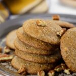 Stack of easy low carb pecan cookies on a rustic plate with chopped pecans