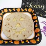 Low carb Halloween quesadilla with a jack-o'-lantern face on a Halloween paper plate