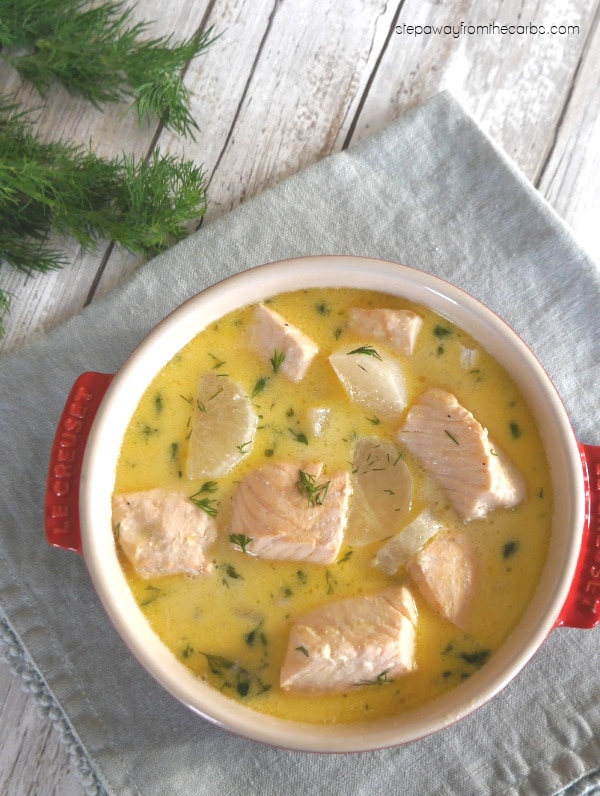 Overhead view of keto salmon soup in a red bowl with fresh dill