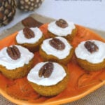 Keto pumpkin muffins topped with maple cream cheese frosting and a pecan