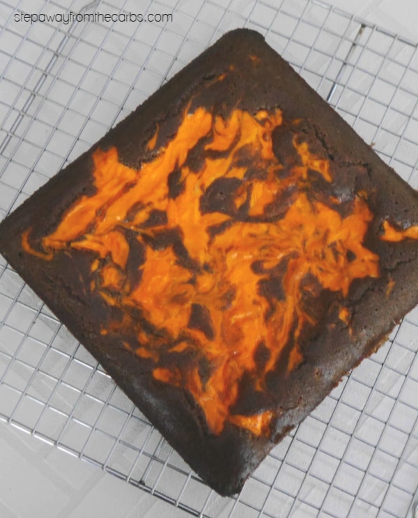 Baked keto Halloween brownie slab with orange swirl cooling on a wire rack
