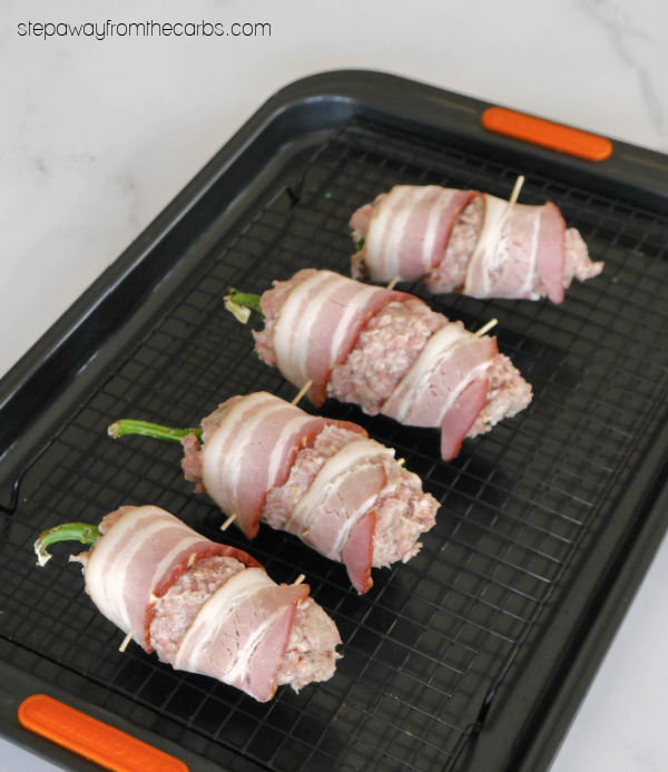 Keto Armadillo Eggs - cheese-stuffed jalapeños wrapped in ground sausage and bacon!