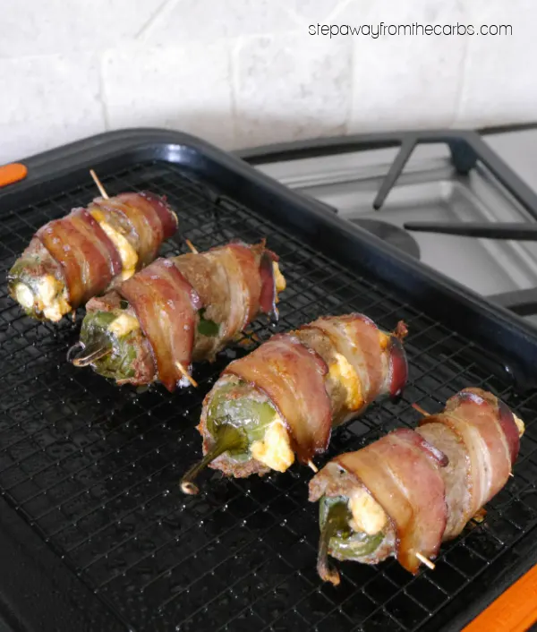 Keto Armadillo Eggs - cheese-stuffed jalapeños wrapped in ground sausage and bacon!