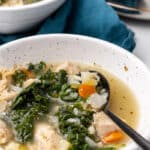 Bowl of chicken kale soup with carrots, celery and cauliflower rice in a light broth