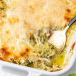 Baked pesto spaghetti squash with melted mozzarella and parmesan in a white baking dish