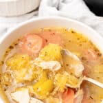 Bowl of spaghetti squash noodle soup with shredded chicken, carrots and celery