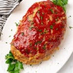 Whole keto turkey meatloaf with a sugar free ketchup glaze on a white platter