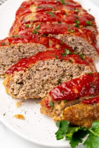 Close-up of sliced keto turkey meatloaf topped with sugar free ketchup and parsley