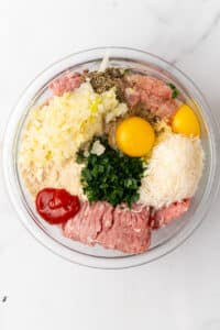 Ground turkey, eggs, Parmesan, almond flour, onion and parsley in a glass mixing bowl