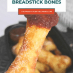 Halloween fathead breadstick bones Pinterest pin with a hand holding a dipped bone