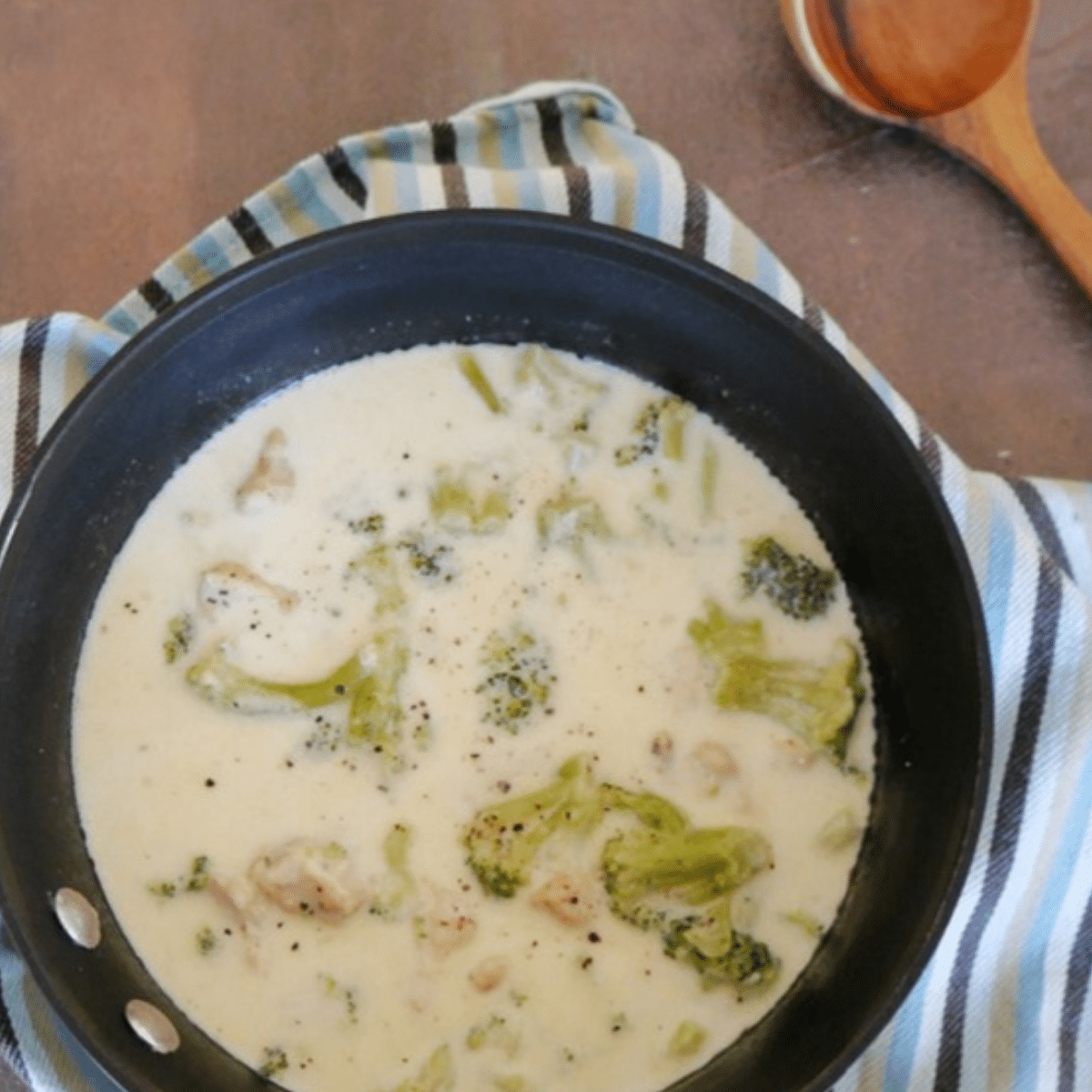 Keto Alfredo soup with chicken and broccoli in a black saucepan
