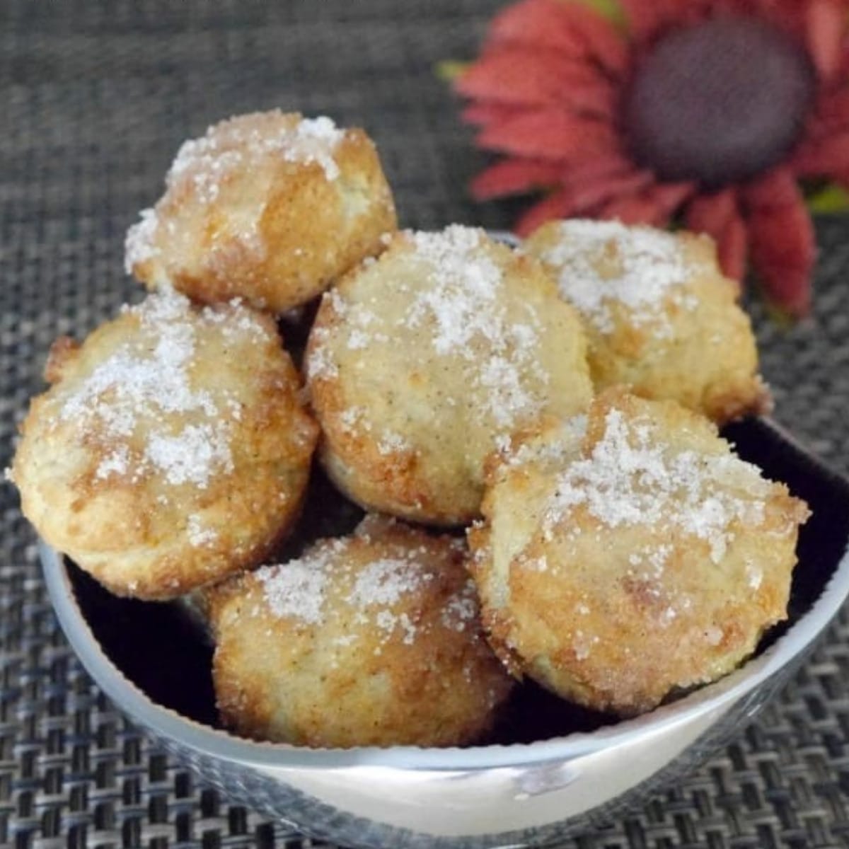 Keto apple cinnamon donut bites coated in cinnamon sweetener in a white bowl