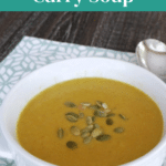 Keto Coconut Curry Soup Pinterest pin showing a bowl of soup topped with pumpkin seeds
