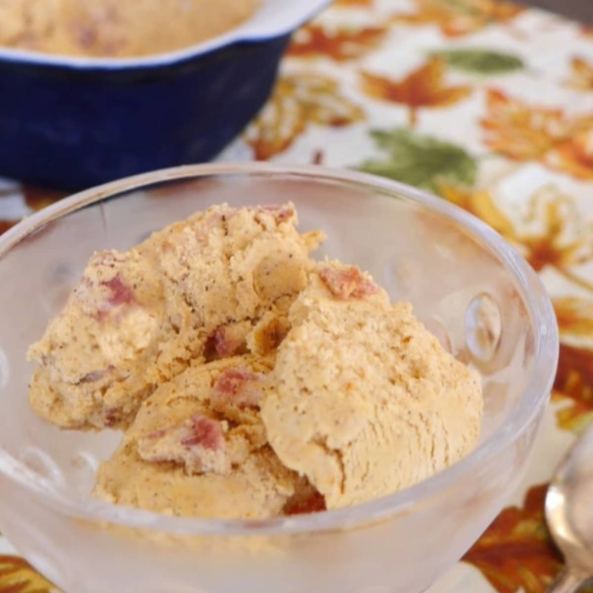 Scoops of keto pumpkin ice cream with candied bacon pieces in a glass dessert dish
