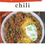 Low carb chili Pinterest pin with a bowl of beanless chili topped with cheese and sour cream