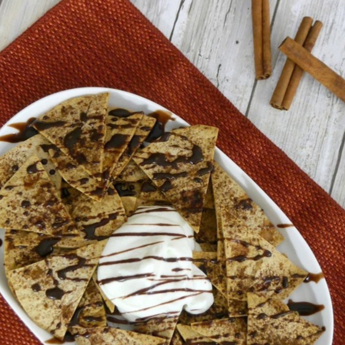 Low carb cinnamon chips on a platter with whipped cream and chocolate drizzle