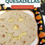 Low carb Halloween quesadillas Pinterest pin with melted cheese showing through a jack-o'-lantern face