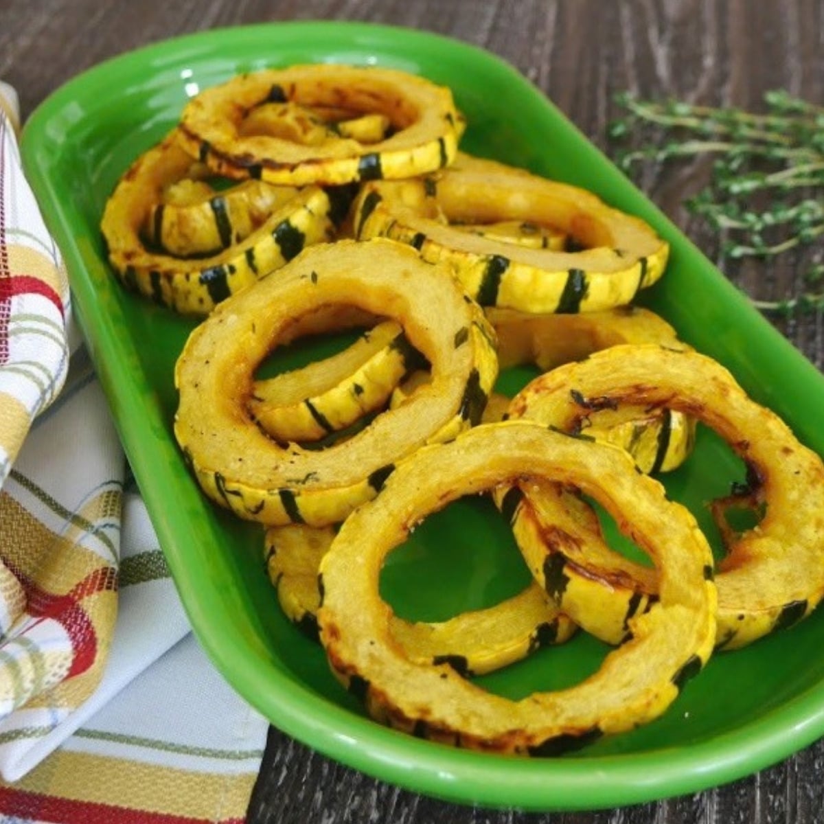 Roasted low carb maple delicata squash rings on a green platter