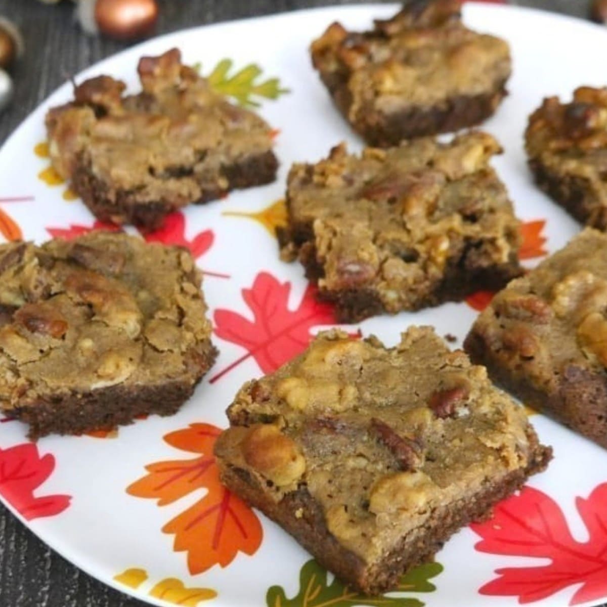 Squares of low carb pecan pie brownies on an autumn leaf plate