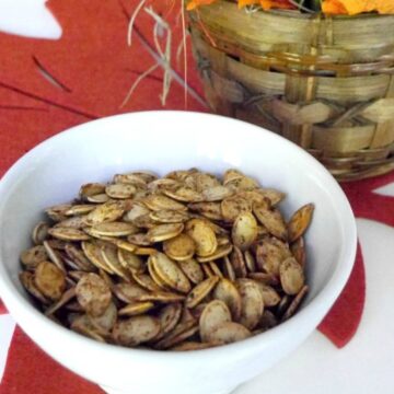 Roasted pumpkin seeds with pumpkin pie spice in a white bowl