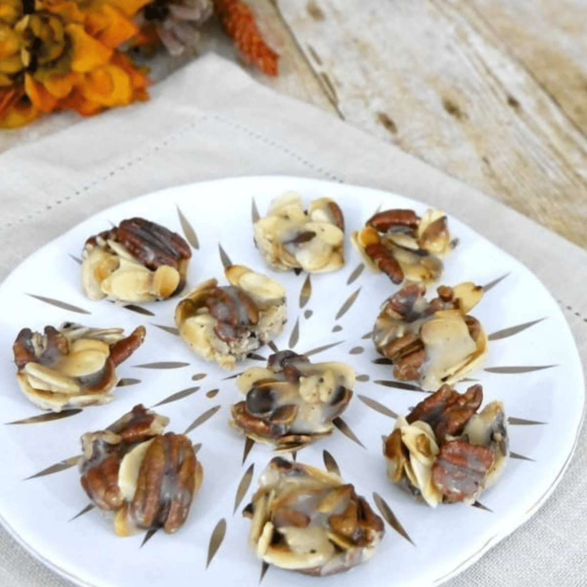 Keto maple nut pralines with pecans and almonds on a white plate