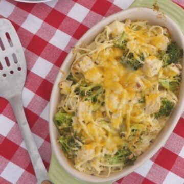 Low carb cheesy chicken noodle casserole with broccoli and melted cheddar in a green baking dish