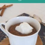 Low carb chocolate mug cake in a white cup topped with whipped cream
