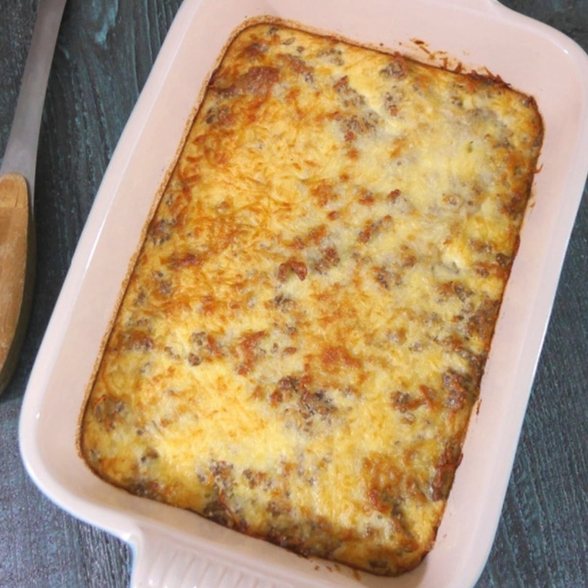 Low carb sausage bake with golden melted cheese in a white baking dish