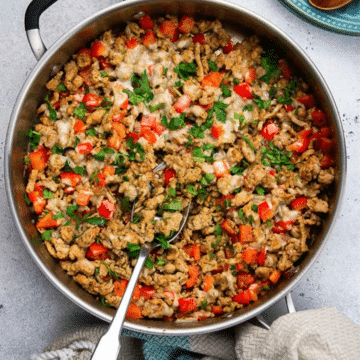 Low carb turkey taco skillet with ground turkey, red bell pepper, melted cheese and cilantro in a large pan