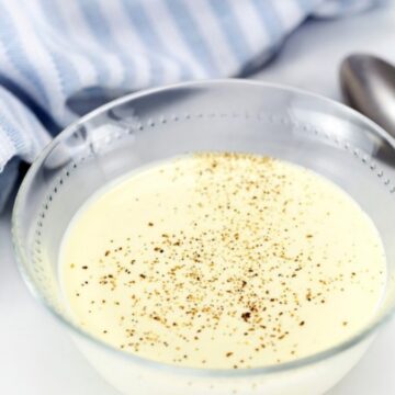 Low carb white sauce in a glass bowl topped with cracked black pepper